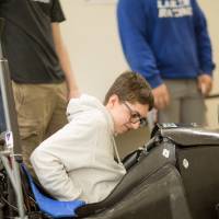 high school students sitting in a laker racer car